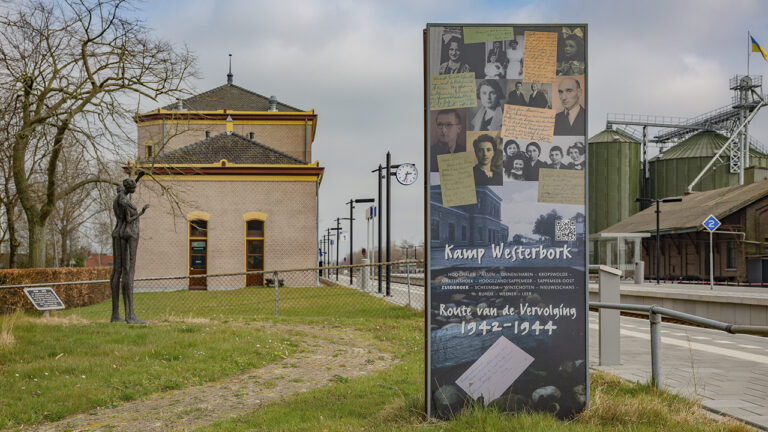 Herdenkingszuil met op de achtergrond het kunstwerk van Anita Franken bij het station in Zuidbroek
