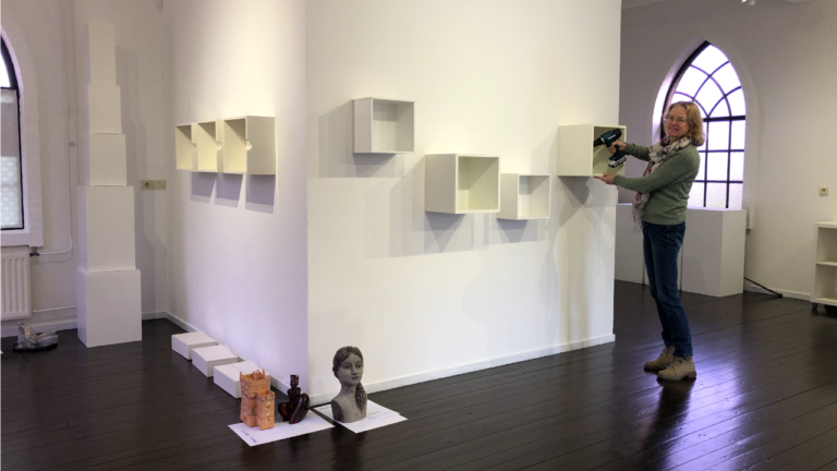 Tetdy Stol tijdens inrichten expositieruimte