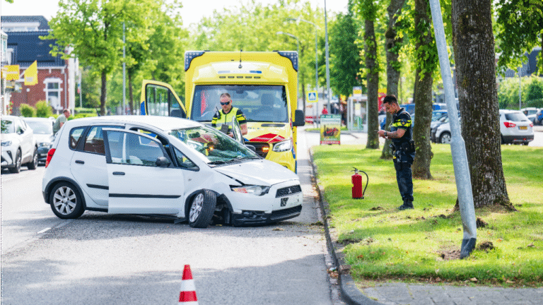 Auto tegen boom en lantaarnpaal op Hoofdstraat in Hoogezand