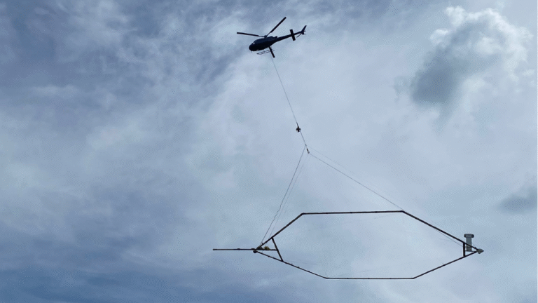 Helikopter met daaronder een groot zeshoeking frame boven Zuidlaardermeer..