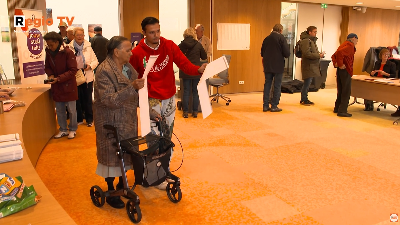 Roshano Dewnarain, GroenLinks MG, stemt samen met z´n oma tijdens landelijke verkiezingen in de raadszaal